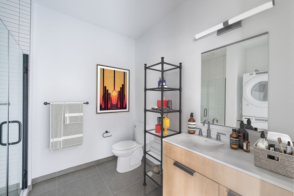 a bathroom with a toilet sink and a shower and a washing machine at The Indie, Boston  