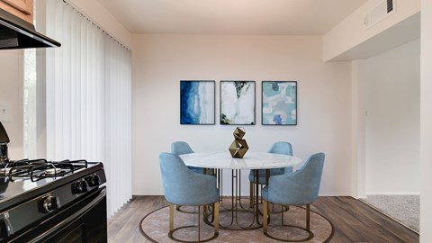 A modern dining room with a black stove and a white table.