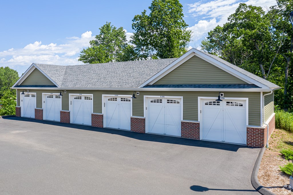 A building with a grey roof and white garage doors.