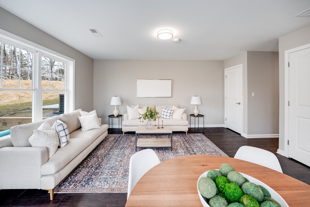 a living room with white couches and a wooden table at Pleasant View Estates, Griswold, 06351