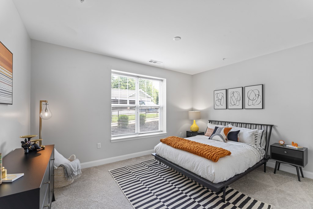 A bedroom with a large bed and a desk.