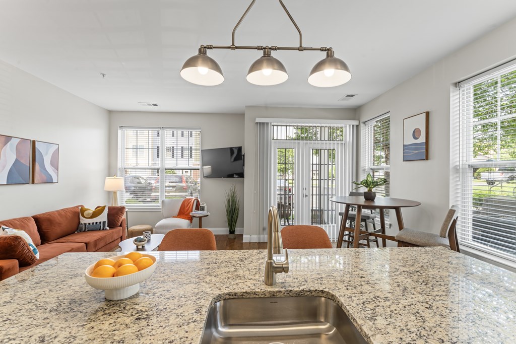 A kitchen with a marble countertop and a bowl of oranges on it.