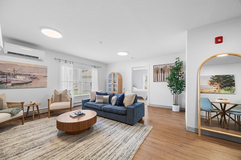 A living room with a blue couch and a wooden coffee table.