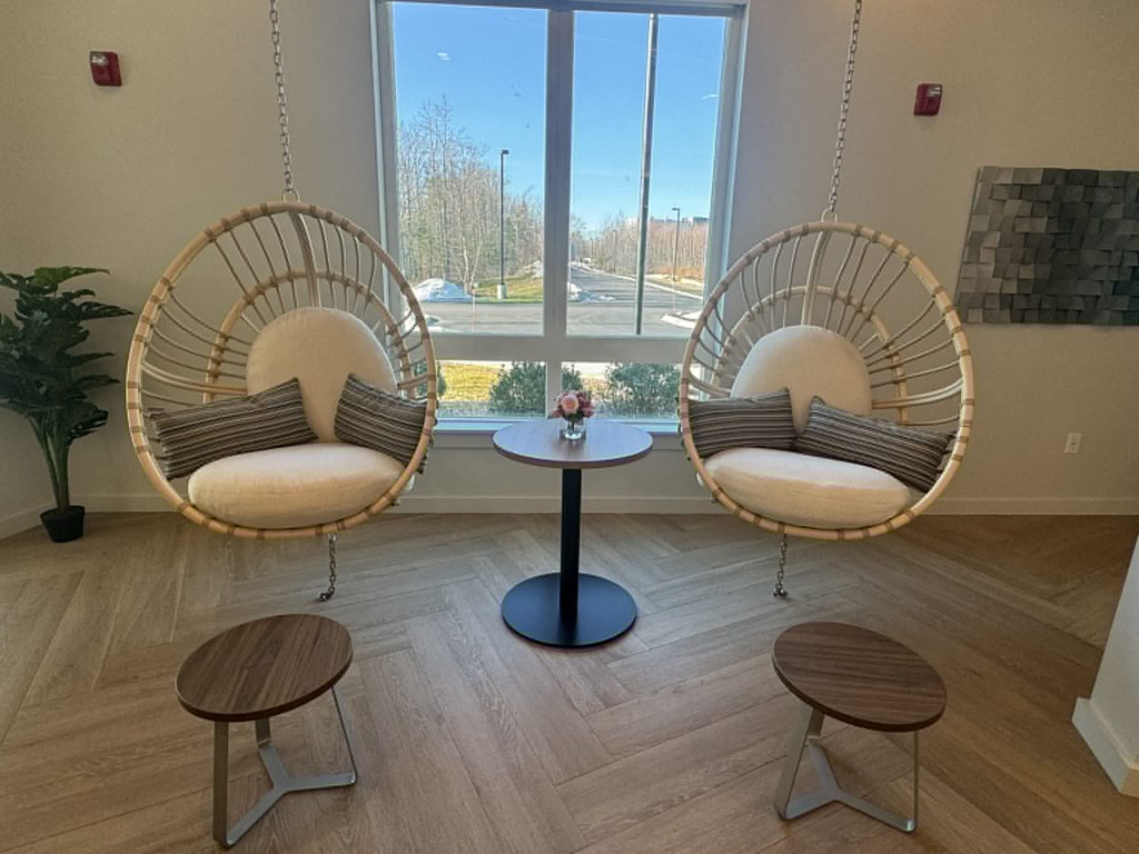 Trendy egg chairs that hang from the ceiling with cushions and side tables