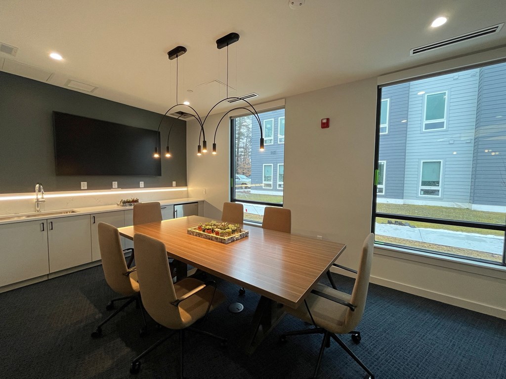 a conference room with a wooden table and chairs and a large window