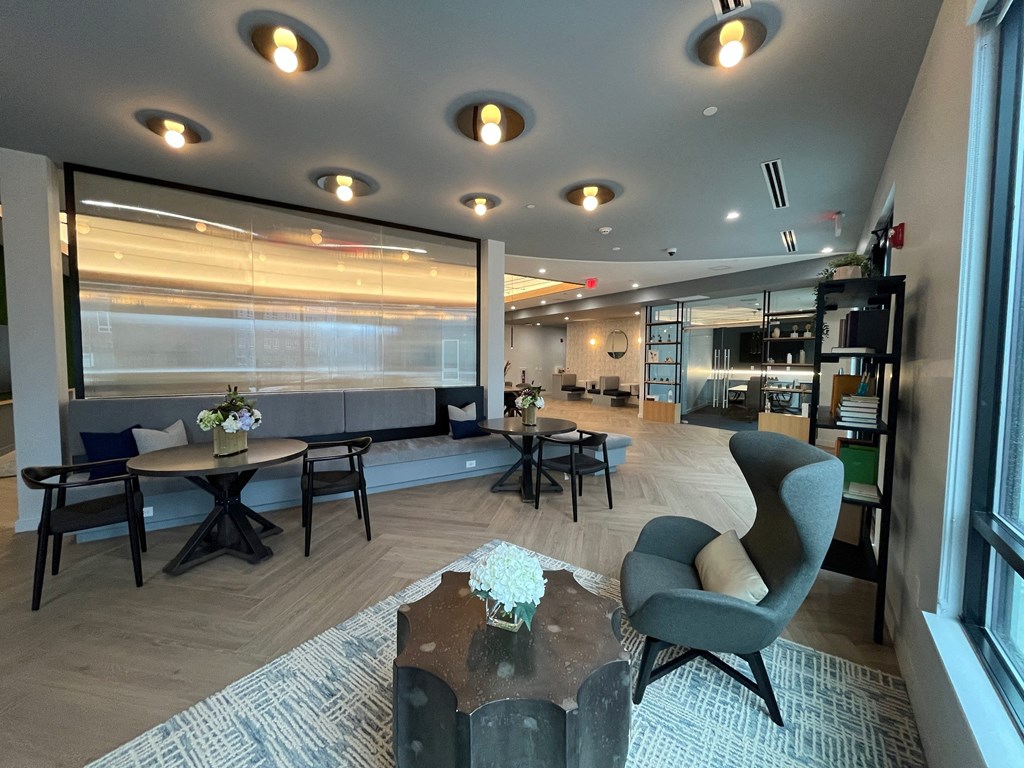 a large lobby with tables and chairs and a large window