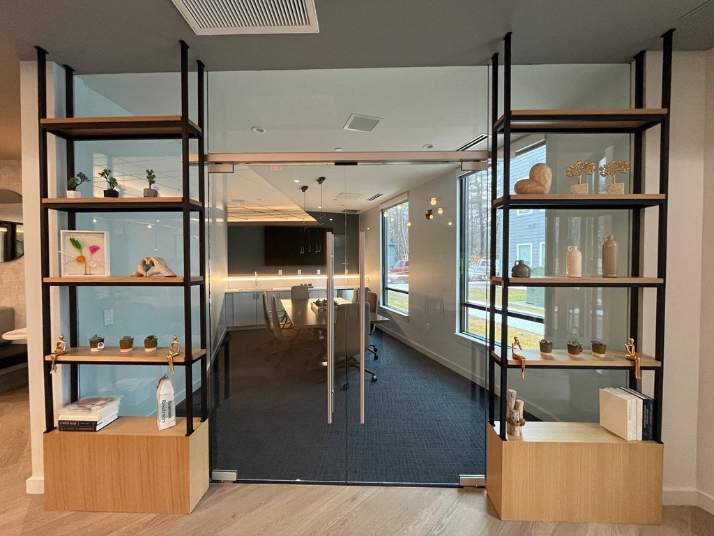 a conference room with glass shelves filled with vases