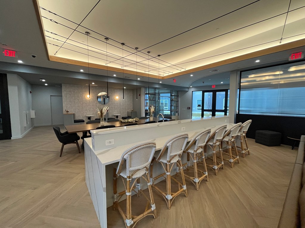 a long bar with chairs in front of a counter in a lobby