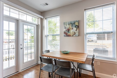 A dining room with a table and chairs.