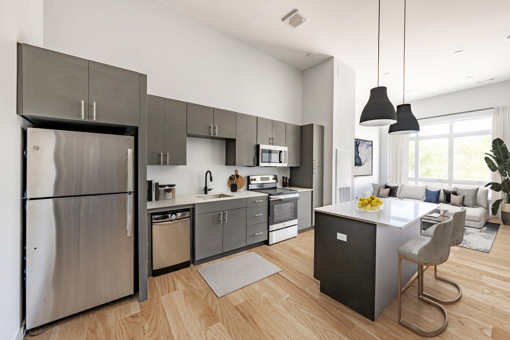 a kitchen with stainless steel appliances and a large island with a breakfast bar at Seacoast Residences Apartments, Oakland, ME