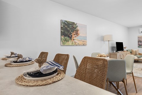 Dining table with woven placemats and coastal artwork at Pointe28 Apartments, Brunswick