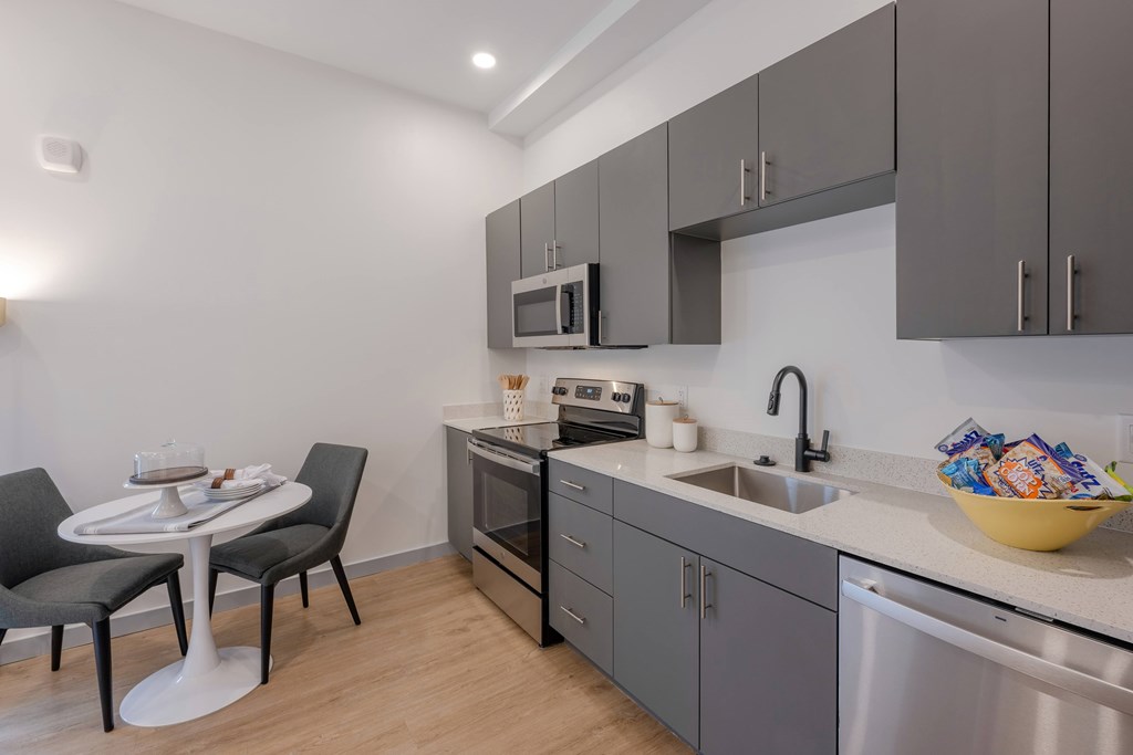 A modern kitchen with a table and chairs. A modern kitchen with a table and chairs at Seacoast Residences Apartments, Maine