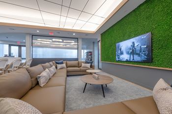 A modern living room with a green wall and a large screen TV.