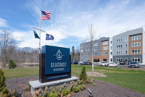 A sign for Seacoast Residences stands in front of a building.