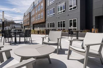 A patio with a table and chairs is in front of a building.