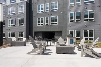 A grey building with a patio area in front.