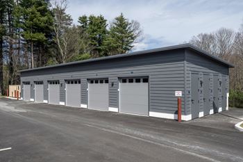 A grey building with multiple garage doors.