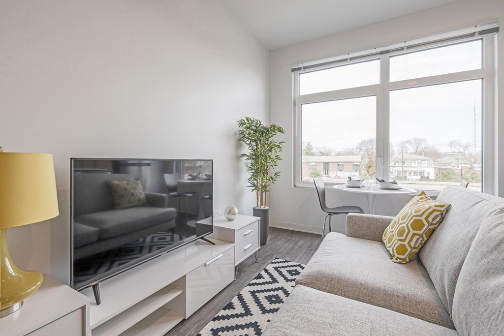 a living room with a couch and a tv and a window at The Indie, Boston, MA 02134  