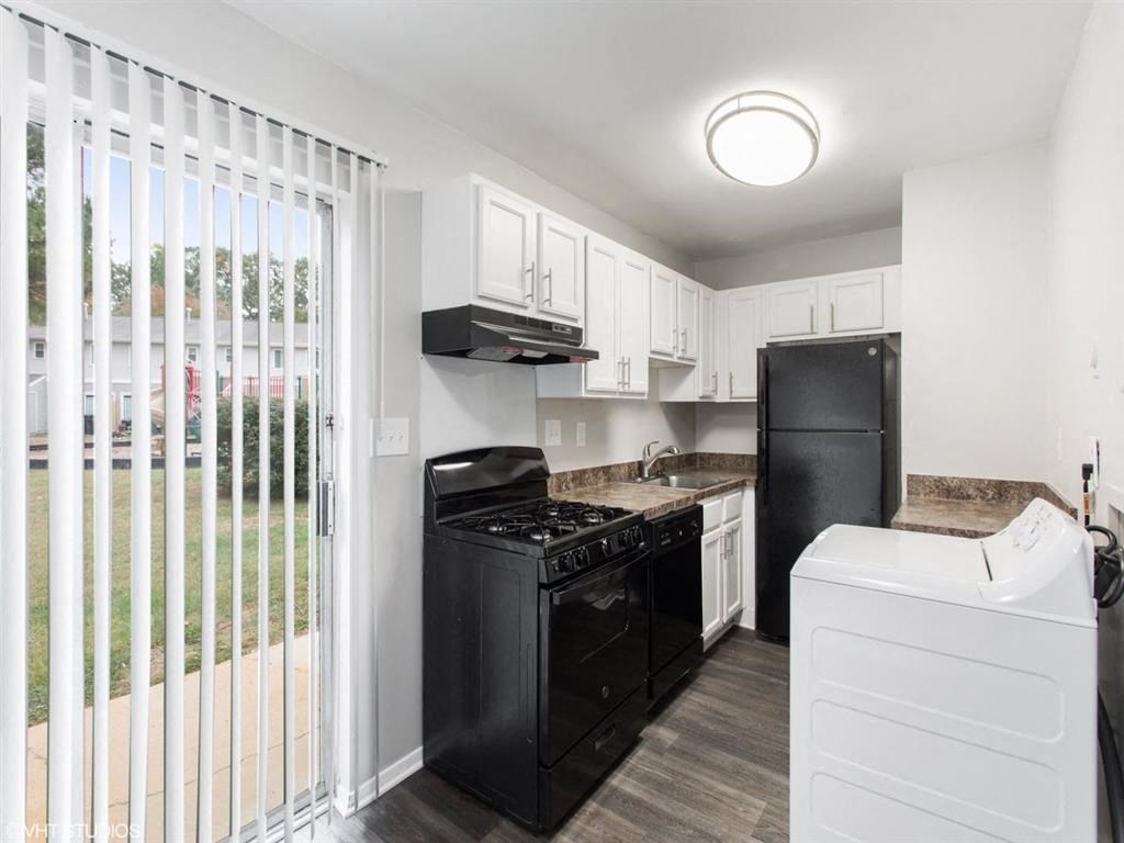 a kitchen with a black stove top oven next to a refrigerator