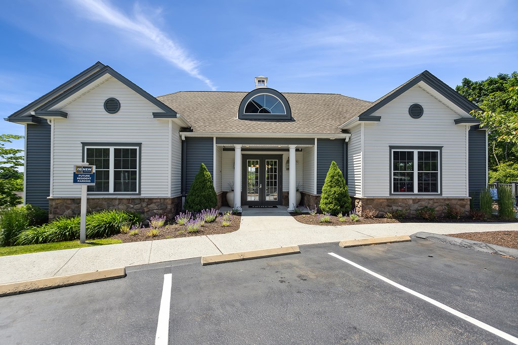 A building with a grey and white facade and a circular window above the door.
