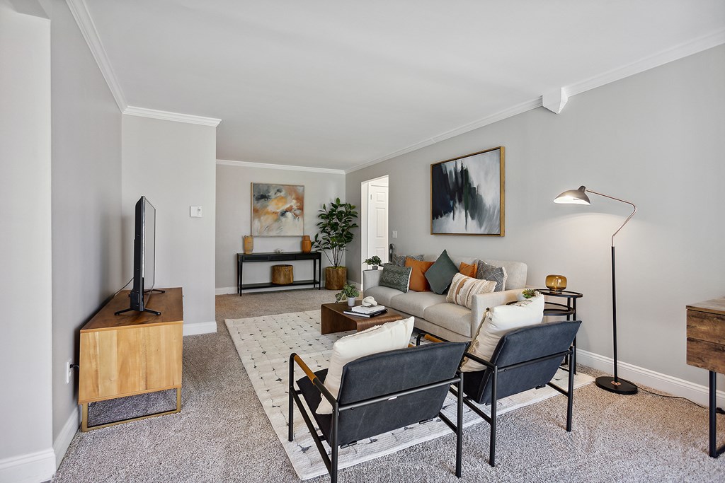 A living room with a couch, chair, and television.