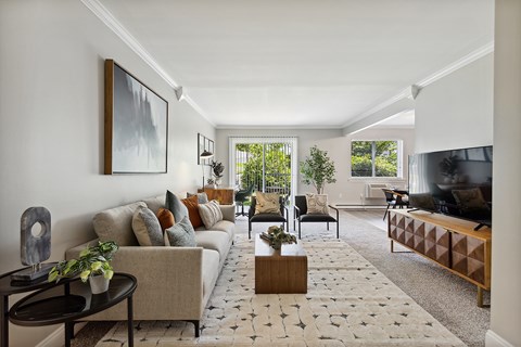 A living room with a couch, coffee table, and a painting on the wall.