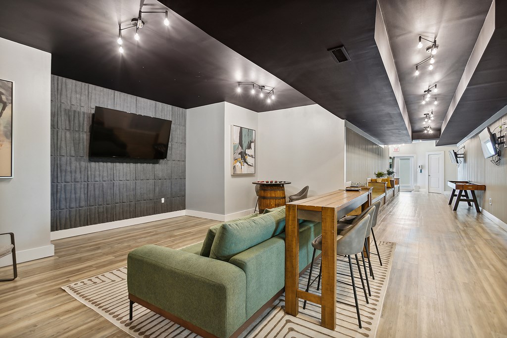A living room with a green couch and a wooden table.