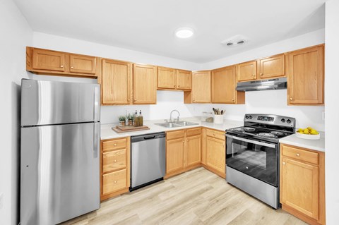 A modern kitchen with wooden cabinets and stainless steel appliances.