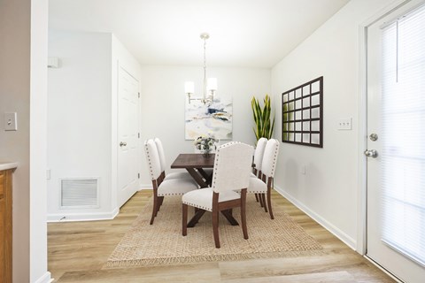 A dining room with a table and chairs.
