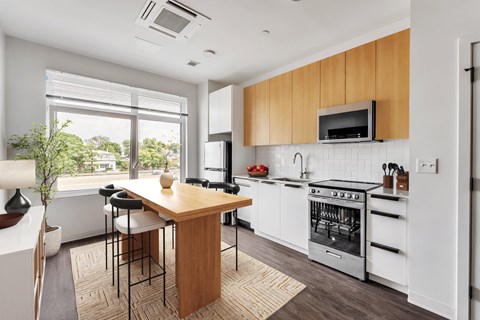 A modern kitchen with white appliances and wooden cabinets.