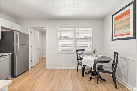 a kitchen and dining room with a table and chairs and a refrigerator