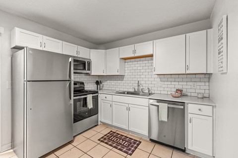 a kitchen with white cabinets and a stainless steel refrigerator