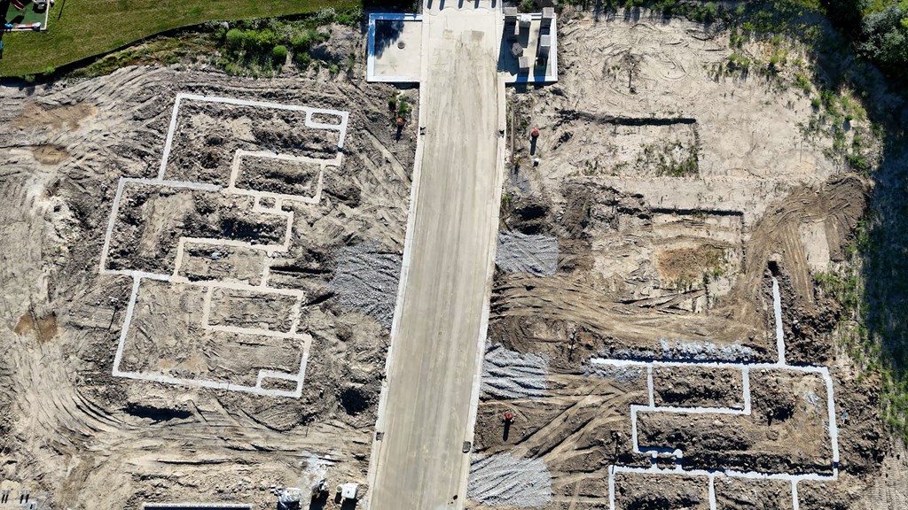 An aerial view of a construction site with a large open area and a road running through it.