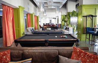 a pool table sits in the middle of a room with couches and chairs