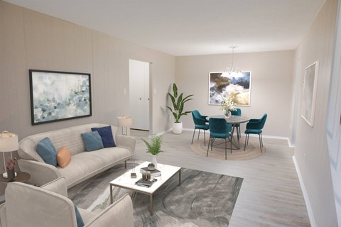 A living room with a grey couch, a coffee table, and a dining table set up.