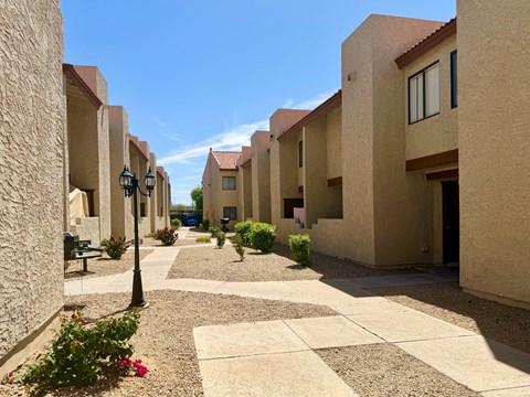 A sunny day in a courtyard surrounded by beige buildings.