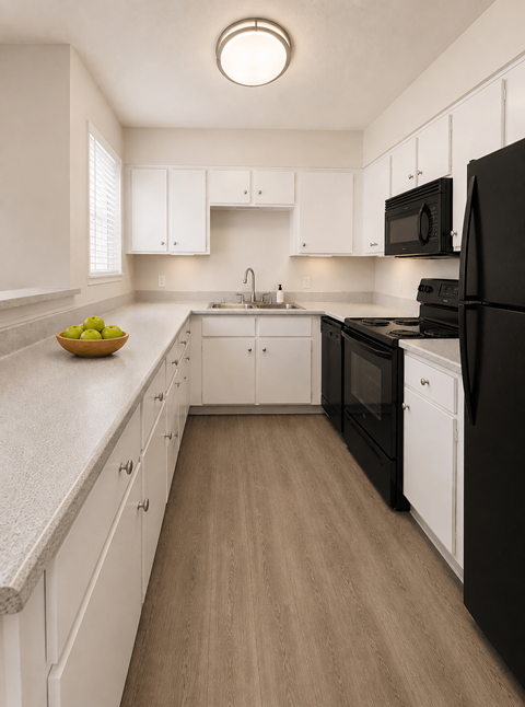A kitchen with black appliances and white cabinets.