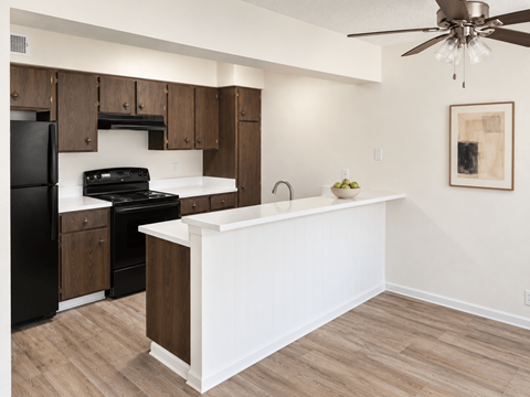 A kitchen with black appliances and wooden cabinets.