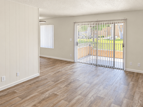 A room with a sliding door leading to a backyard.