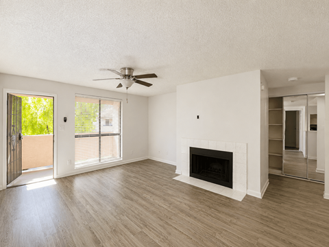 A spacious living room with a fireplace and sliding glass doors.