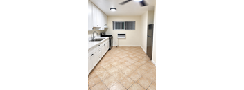 A kitchen with white cabinets and a black stove top oven.