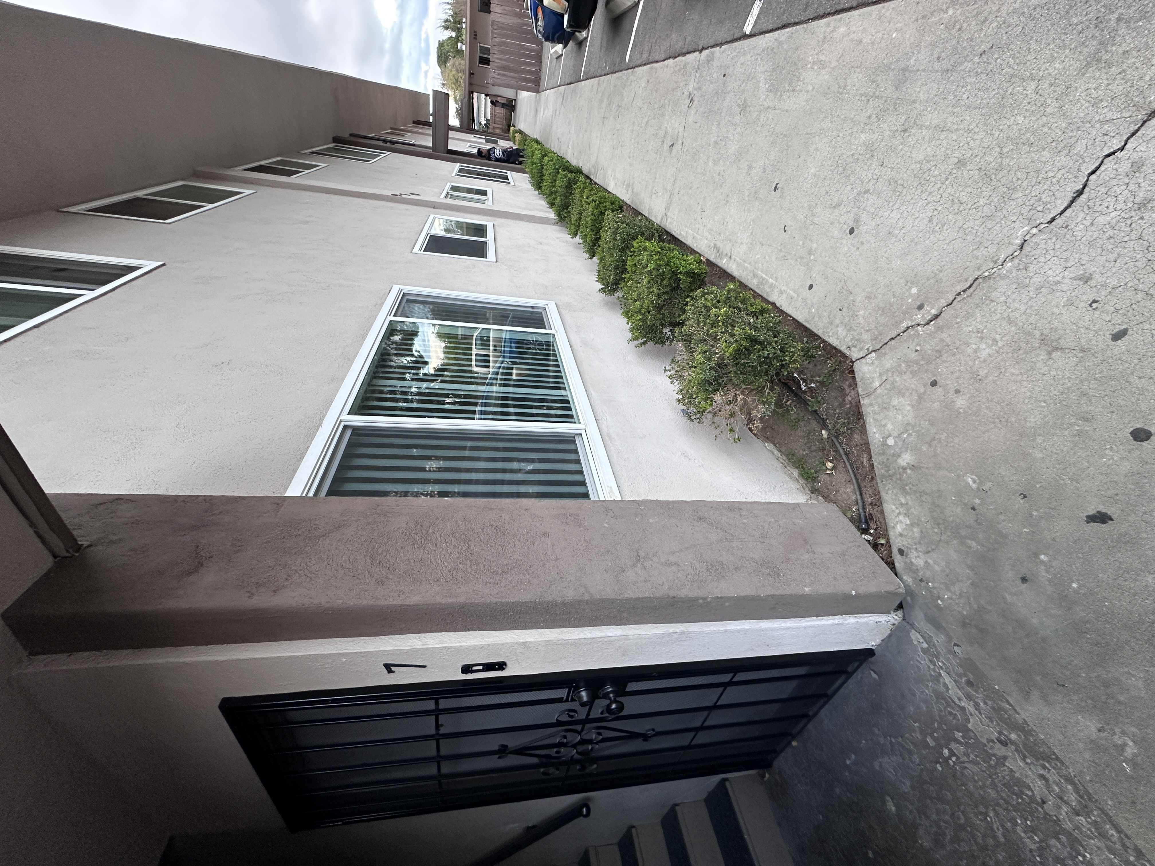 A concrete staircase with a metal grate in the middle and a wall on the right side.