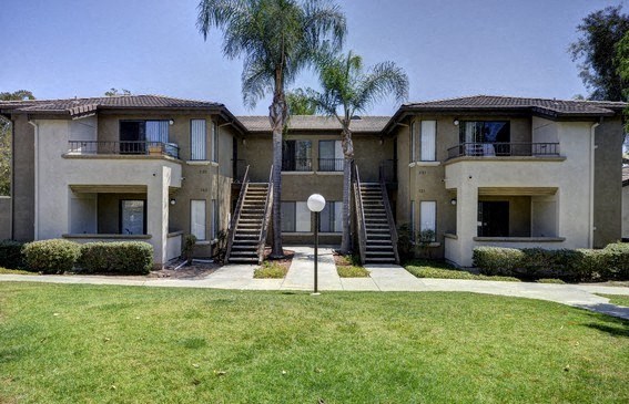 an apartment building with stairs and palm trees