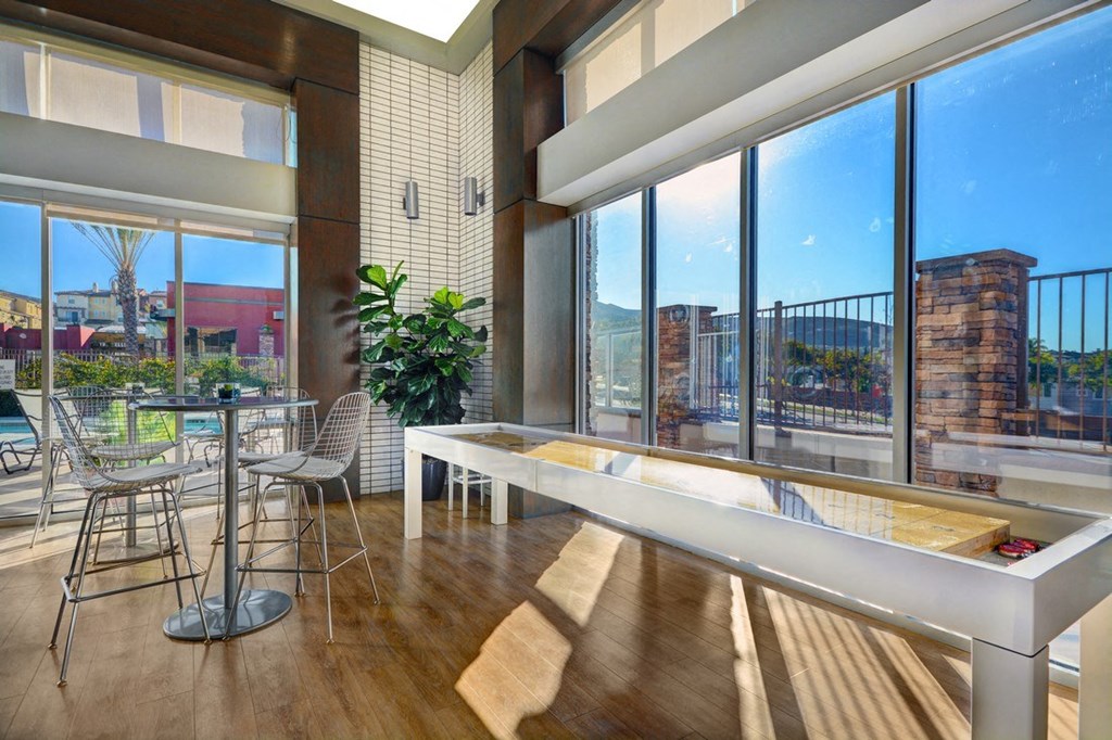 a living room with a large window and a table with chairs