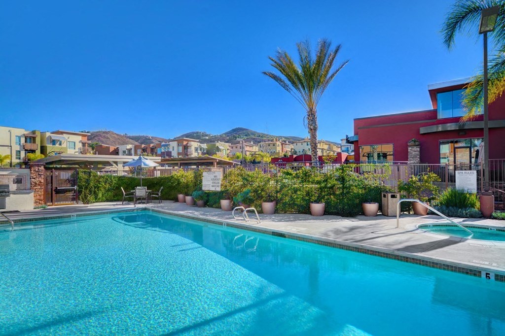 a swimming pool with palm trees and buildings in the background