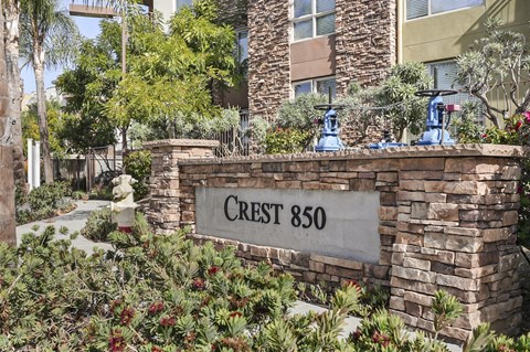 a stone wall with a sign that reads crest 860 in front of a building
