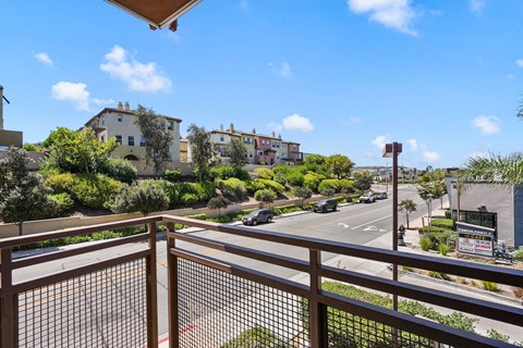 a view of the street from a balcony with a fence