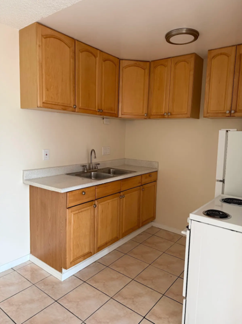 A kitchen with wooden cabinets and a white dishwasher.