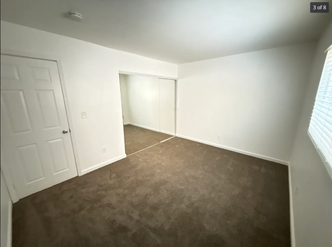 A room with brown carpet and white walls.