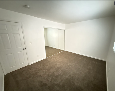 A room with brown carpet and white walls.